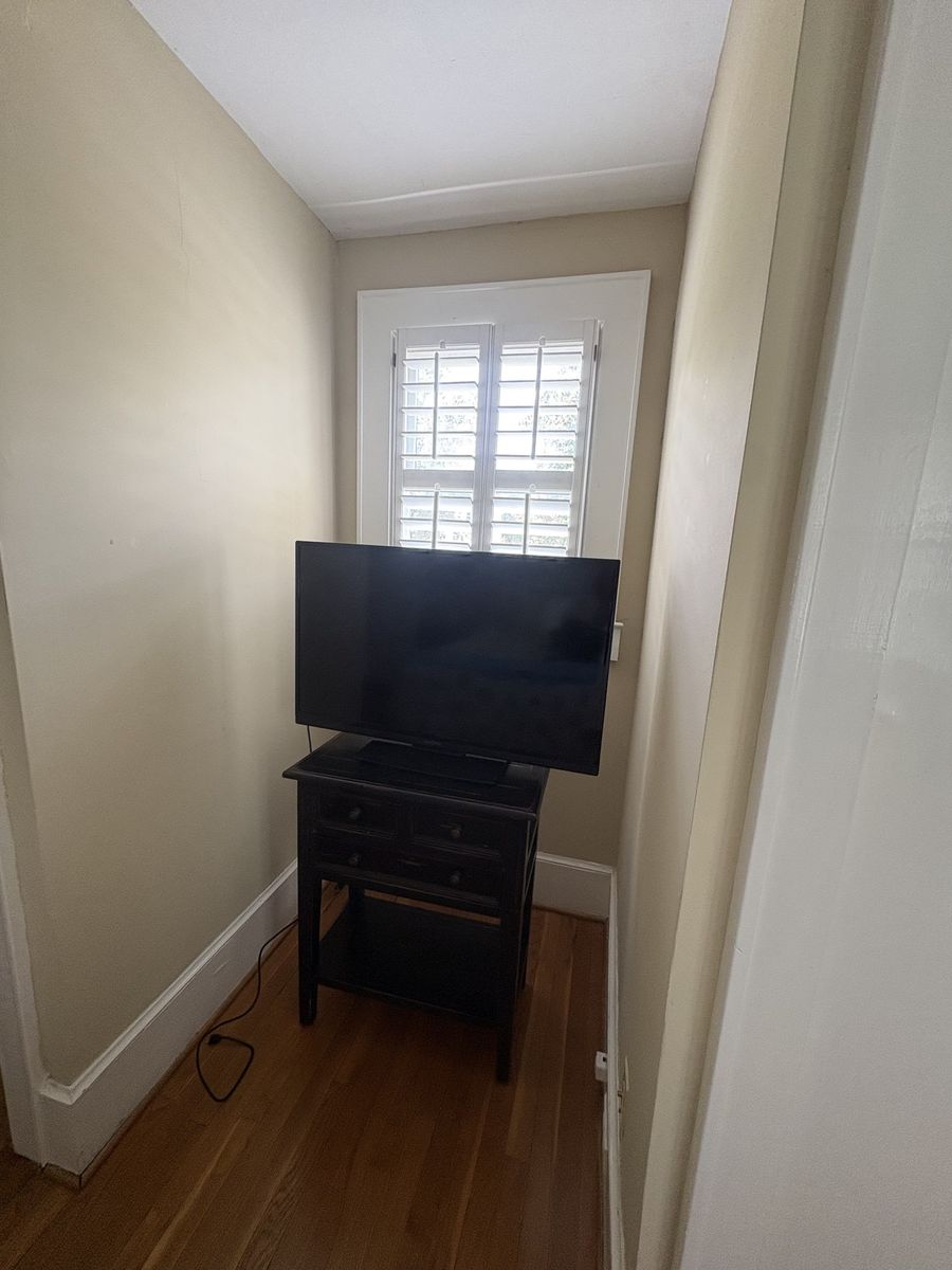 Before: narrow window nook holding a TV on a small stand