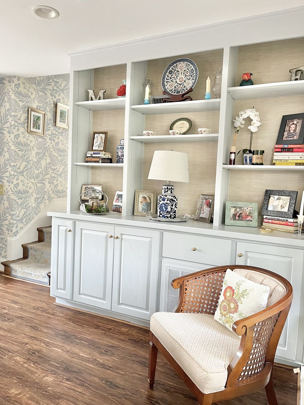 Pale blue built-in shelves backed in grasscloth, styled with blue-and-white porcelain