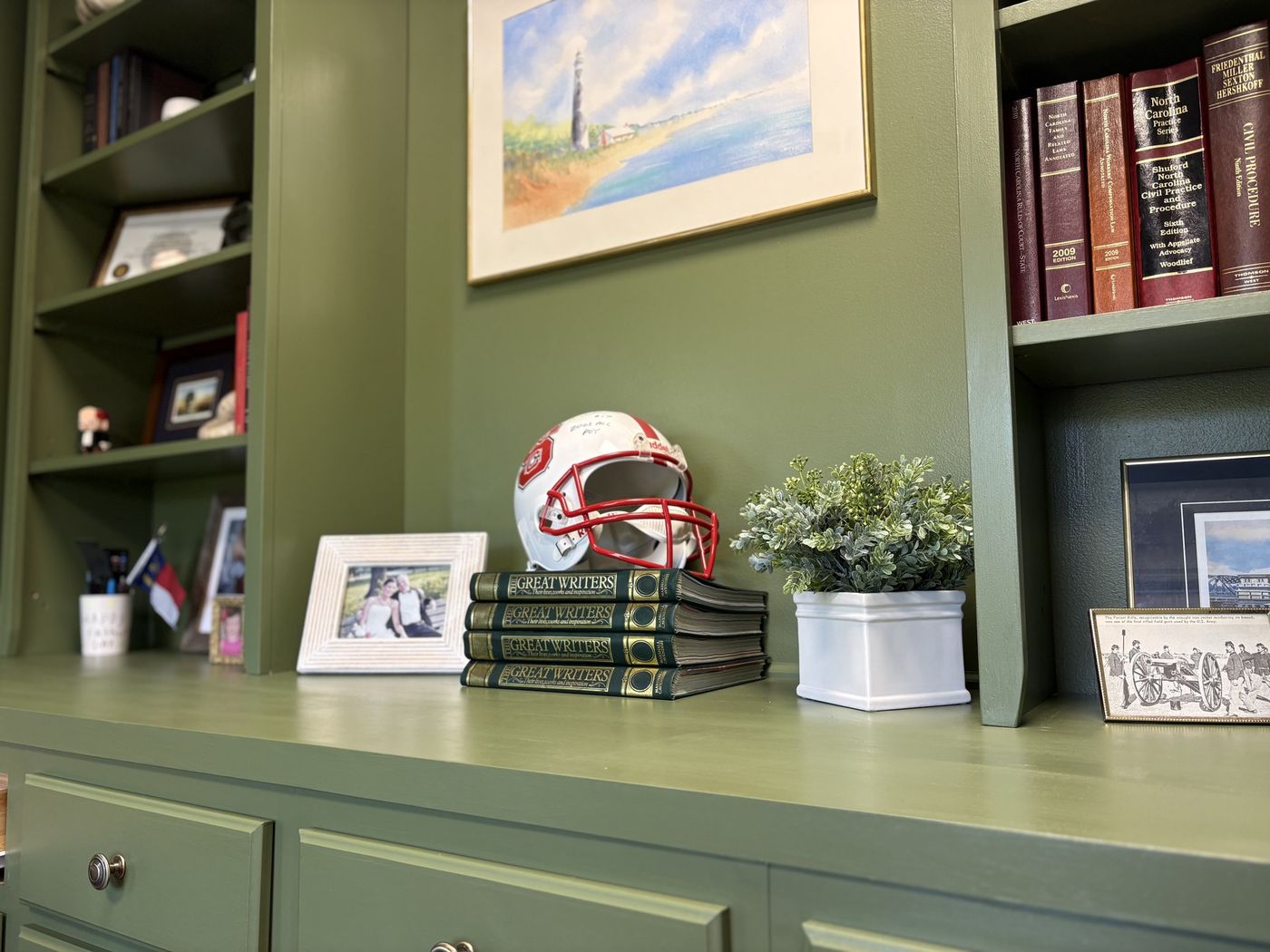 Bookcase detail with a signed football helmet and framed watercolor