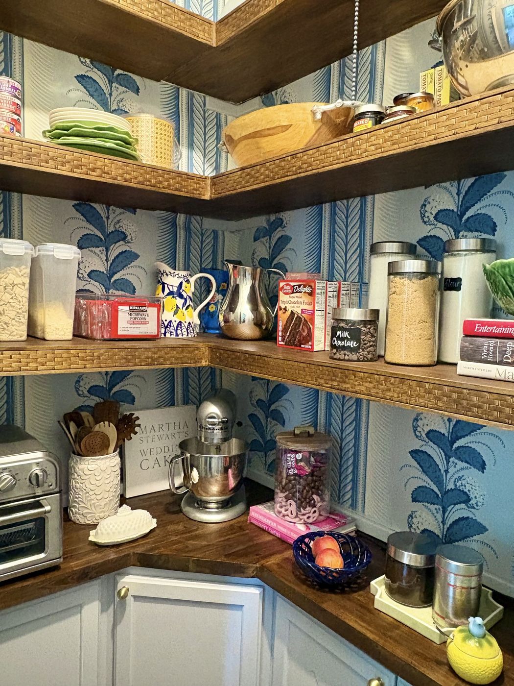 Pantry counter with butcher-block top, stand mixer, and leaf-print wallpaper